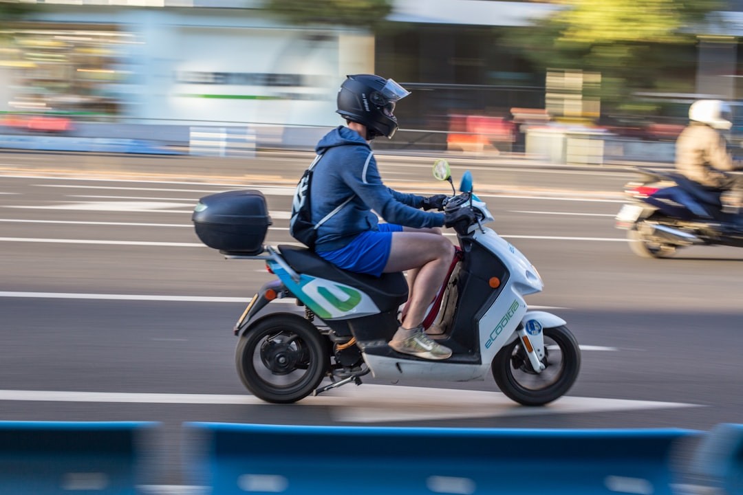 man in blue jacket riding blue and black motorcycle